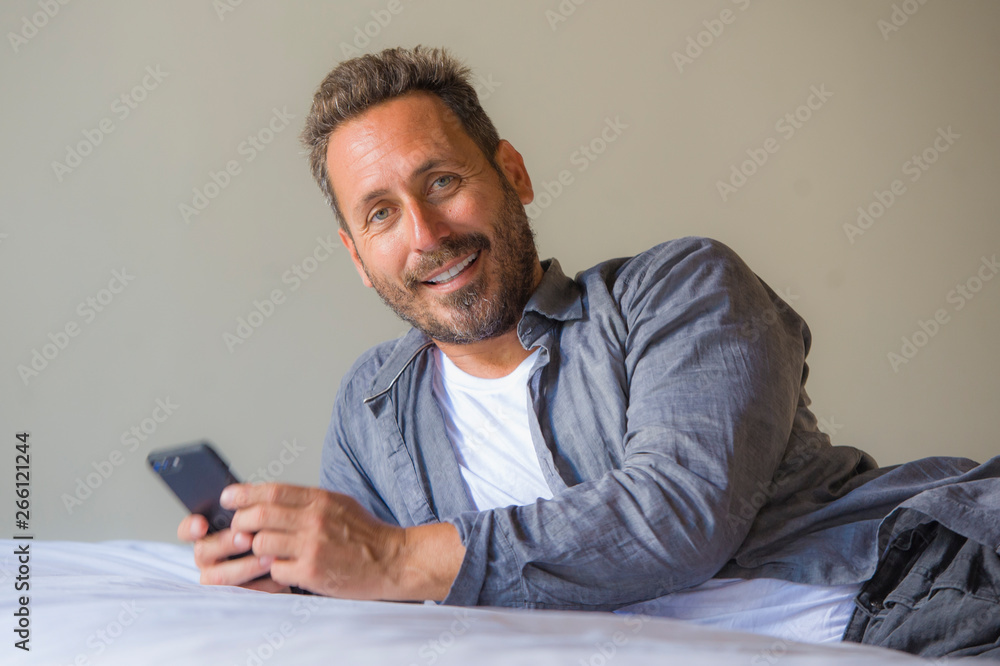 young handsome and happy man at home using internet mobile phone on bed smiling cheerful and satisfied feeling relaxed dating online or enjoying social media app young handsome and happy man at home using internet mobile phone on bed smiling cheerful and satisfied feeling relaxed dating online or enjoying social media app