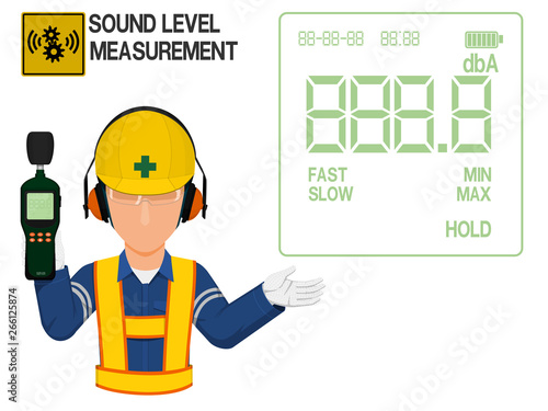 An Industrial worker with earmuffs is presenting display screen of the sound level meter