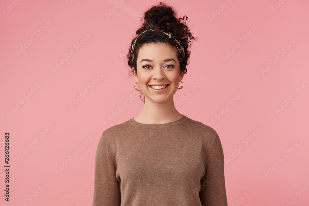 Portrait of happy young beautiful girl with curly dark hair, broadly smiling and looking at the camera isolated over pink background. Portrait of happy young beautiful girl with curly dark hair, broadly smiling and looking at the camera isolated over pink background.