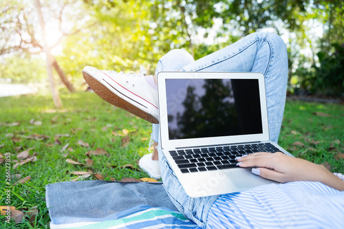 Fototapeta Naklejka Na Ścianę i Meble -  Closeup of young woman using laptop with relax in garden.