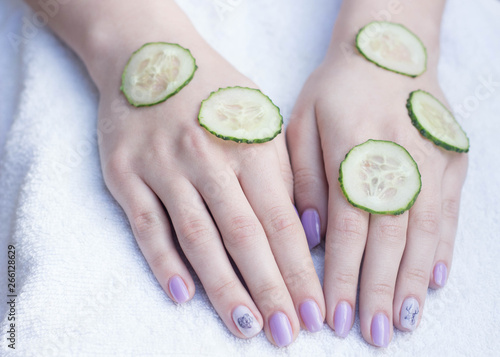 hands of a girl and sliced cucumber cosmetics