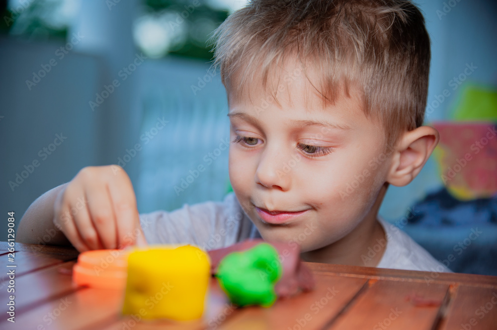smiling child plays on a table with plasticine smiling child plays on a table with plasticine