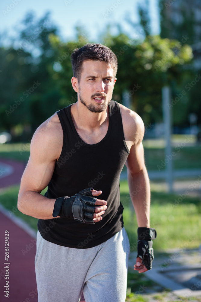 Determined, fit young man running in the city park. Sports and lifestyle in urban environment. Determined, fit young man running in the city park. Sports and lifestyle in urban environment.