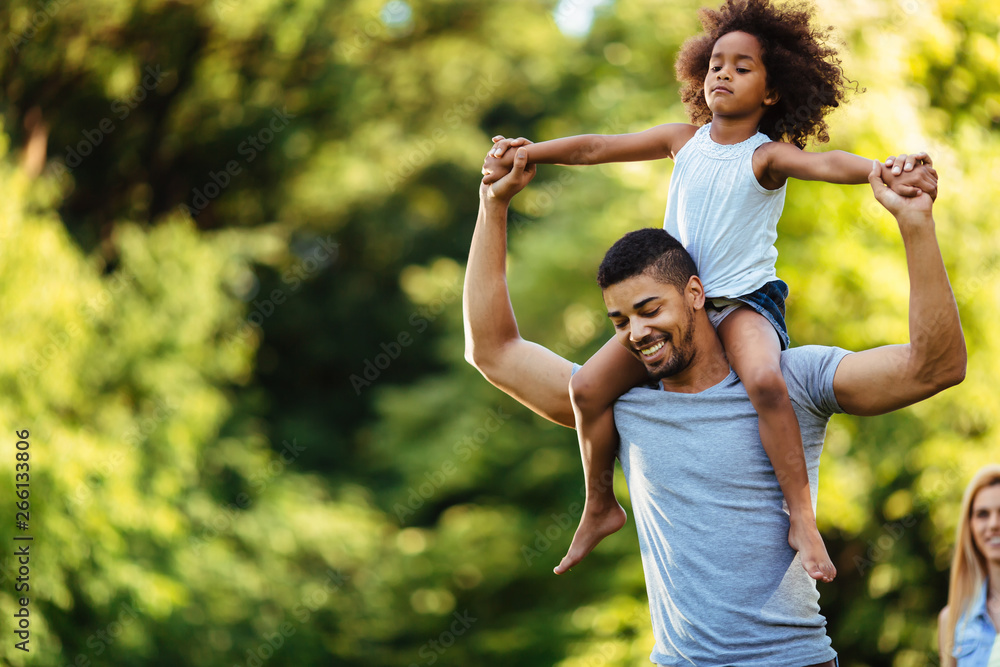 Portrait of young father carrying his daughter on his back Portrait of young father carrying his daughter on his back