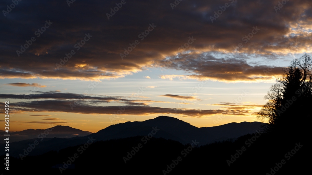 sunrise in the austrian alps shining at mystic clouds up a sleeping valley in styria in the austrian alps