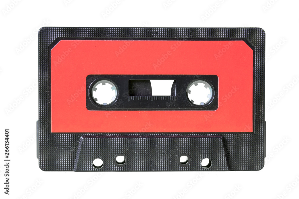 An old retro cassette tape from the 1980s (obsolete music technology). Black fine grid plastic body, red label.