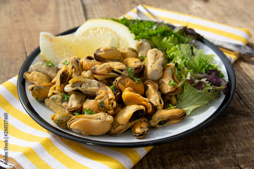 Peeled mussels with fresh lemom. Healthy seafood, natural sunlight, wooden rustic table.