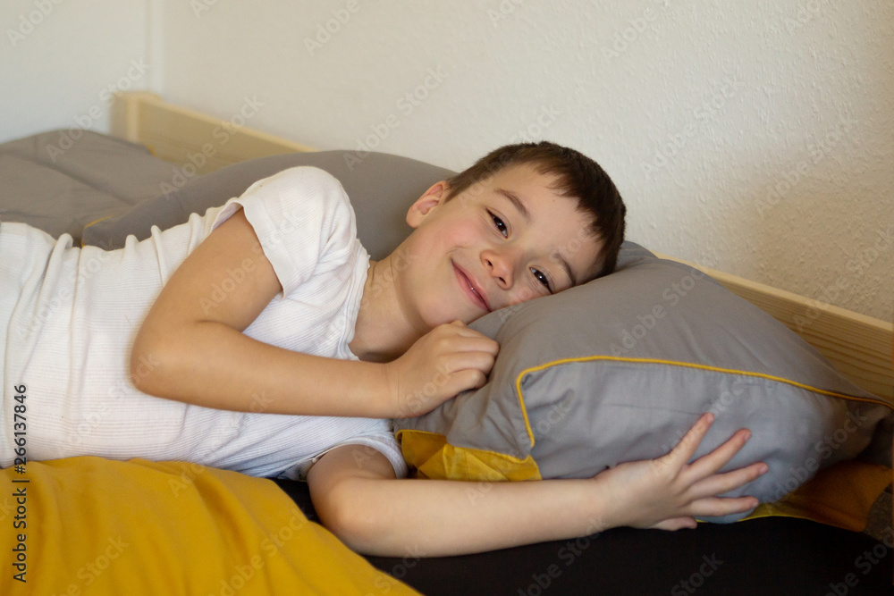 6 years old boy is lying in bed and smiling, close-up 6 years old boy is lying in bed and smiling, close-up