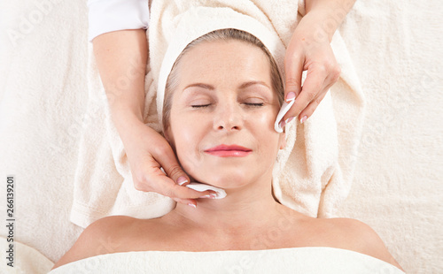 face massage in spa macro. Attractive woman with close eyes taking skin care. Massage face selective focus.