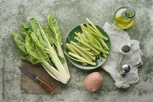 Fotografia borage potatoes olive oil and other raw vegetables, on a marbled green backgroun