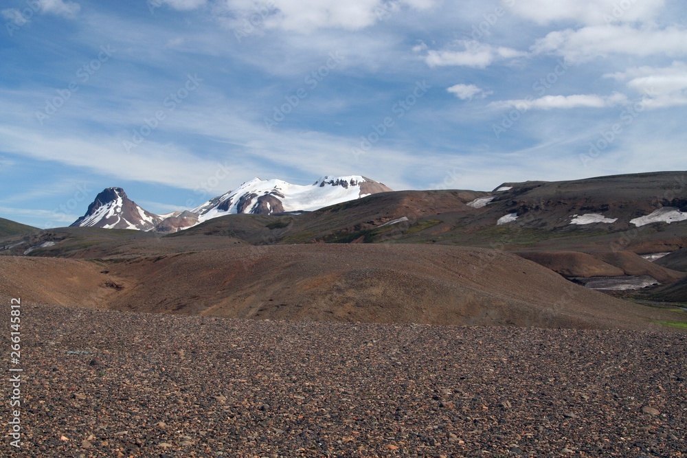 View over barren dry brown hilly rough terrain on snow capped mountains - Iceland