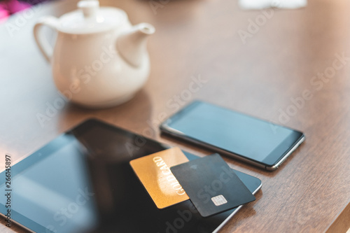 Wallpaper Mural Modern digital tablet with cellular and bank plastic card lying on wooden table in cafe Torontodigital.ca