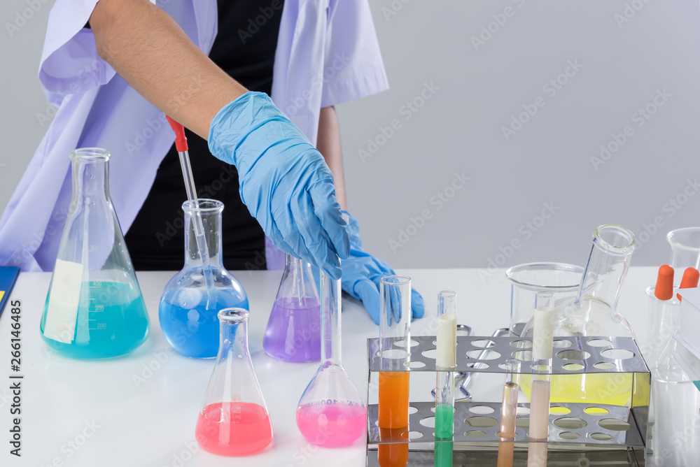 Cheerful chemist woman in lap, or graduate student in lab coat ane protetive wear work,check and test chemistry. Cheerful chemist woman in lap, or graduate student in lab coat ane protetive wear work,check and test chemistry.