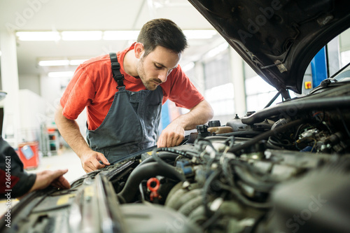 Auto mechanic working in garage. Repair service.