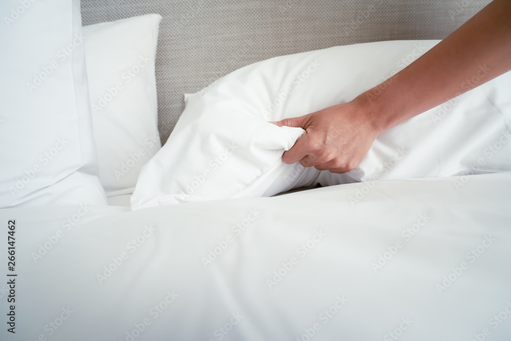 Female Hand set up white bed sheet in room hotel Female Hand set up white bed sheet in room hotel