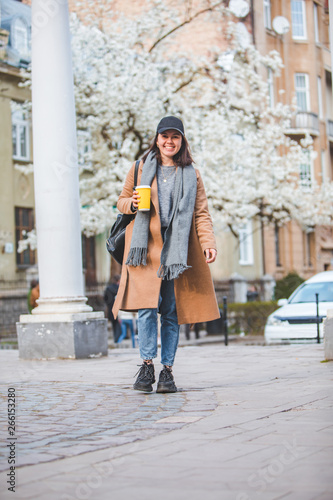young stylish woman walking by street with coffee cup © phpetrunina14