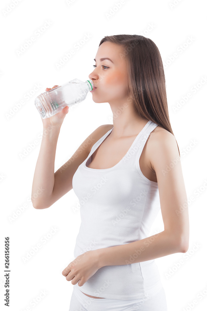 Attractive young woman drinking water on isolated white background. Female holding bottle of water. Attractive young woman drinking water on isolated white background. Female holding bottle of water.