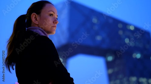 Thoughtful woman enjoy modern cityscape and skyscraper at night