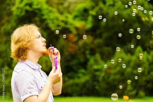 Man blowing soap bubbles outdoor