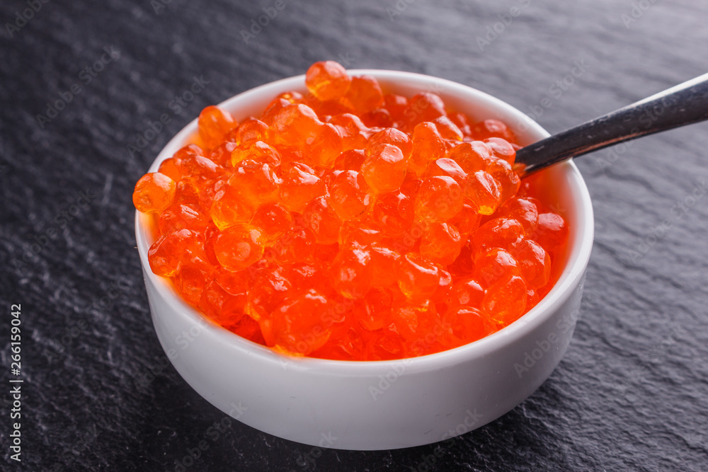 red caviar in a bowl on a dark stone background red caviar in a bowl on a dark stone background