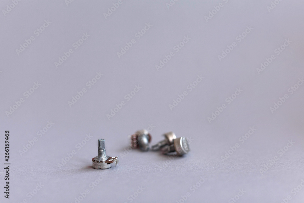 Potentiometers stand on the gray background. Many Potentiometers. Macro close up of electronic component potentiometer Potentiometers stand on the gray background. Many Potentiometers. Macro close up of electronic component potentiometer