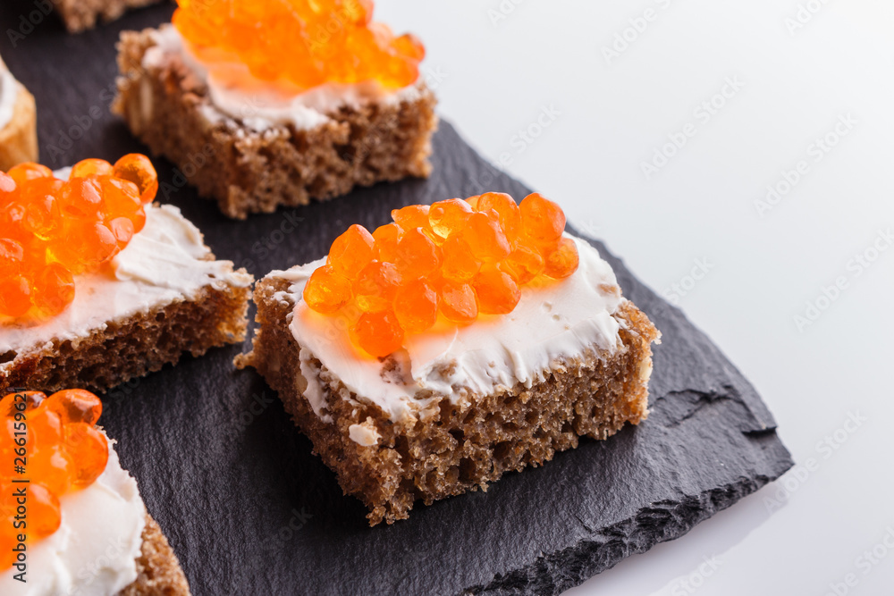 Snack with red and black caviar on a stone plate Snack with red and black caviar on a stone plate