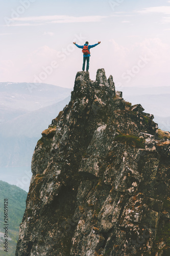 Traveler man on mountain top adventure climbing extreme lifestyle vacations success achievement happy emotions photo