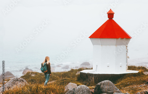 Woman walking at lighthouse foggy sea solo traveling lifestyle adventure scandinavian journey outdoor