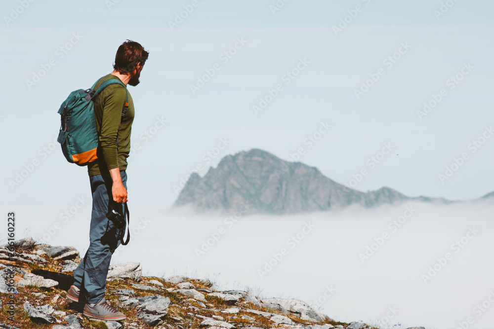 Obraz premium Man solo traveling in mountains adventure vacations freedom lifestyle outdoor with backpack and photo camera