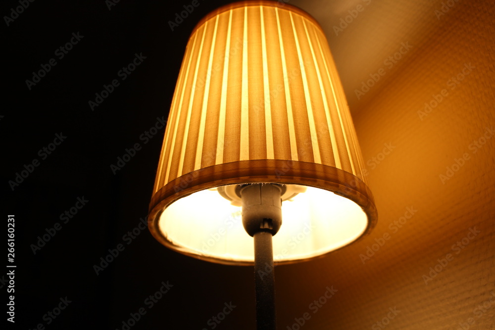 Beautiful lit yellow colored table lamp full view.