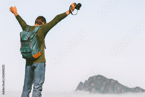 Obraz na plátně Happy man photographer traveling in mountains success raised arms adventure life