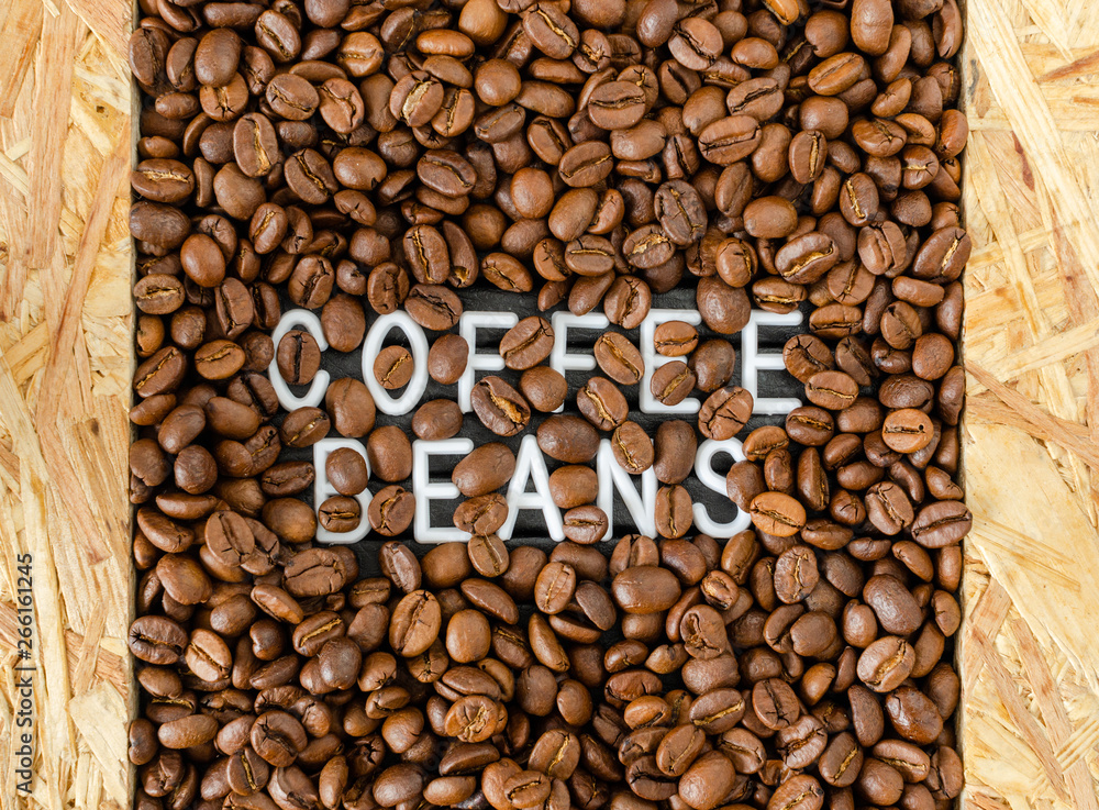 Background with coffee beans with white inscription in the middle.