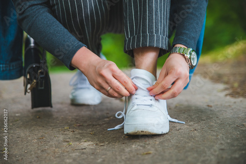 woman tie shoelaces on sneakers