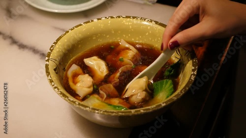 Woman eat yummy chinese dumpling soup