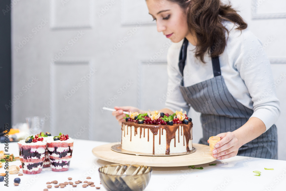 Decoration of the finished dessert. Pastry chef sprinkles confectionery with yellow powder. The concept of homemade pastry, cooking cakes. Decoration of the finished dessert. Pastry chef sprinkles confectionery with yellow powder. The concept of homemade pastry, cooking cakes.