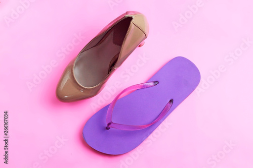 Trendy glamour fancy beige nude pink patent glossy pair of elegant high heels shoes and beach purple beach flip flops on pink background flat lay, high heel against flip flop healthy rested legs conce