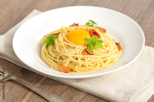 Carbonara pasta, spaghetti with pancetta, egg, hard parmesan cheese, basil and cream sauce. Traditional italian cuisine. 