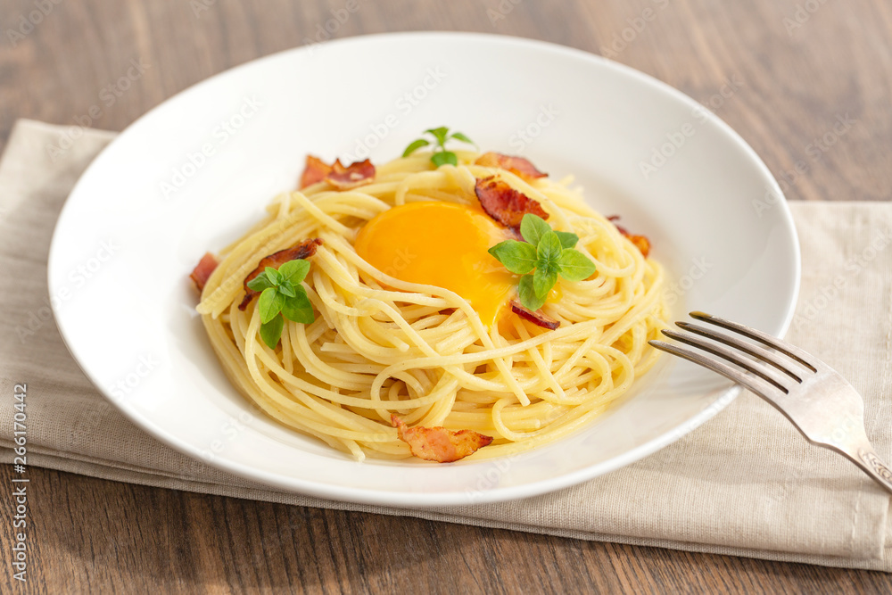 Carbonara pasta, spaghetti with pancetta, egg, hard parmesan cheese, basil and cream sauce. Traditional italian cuisine. 