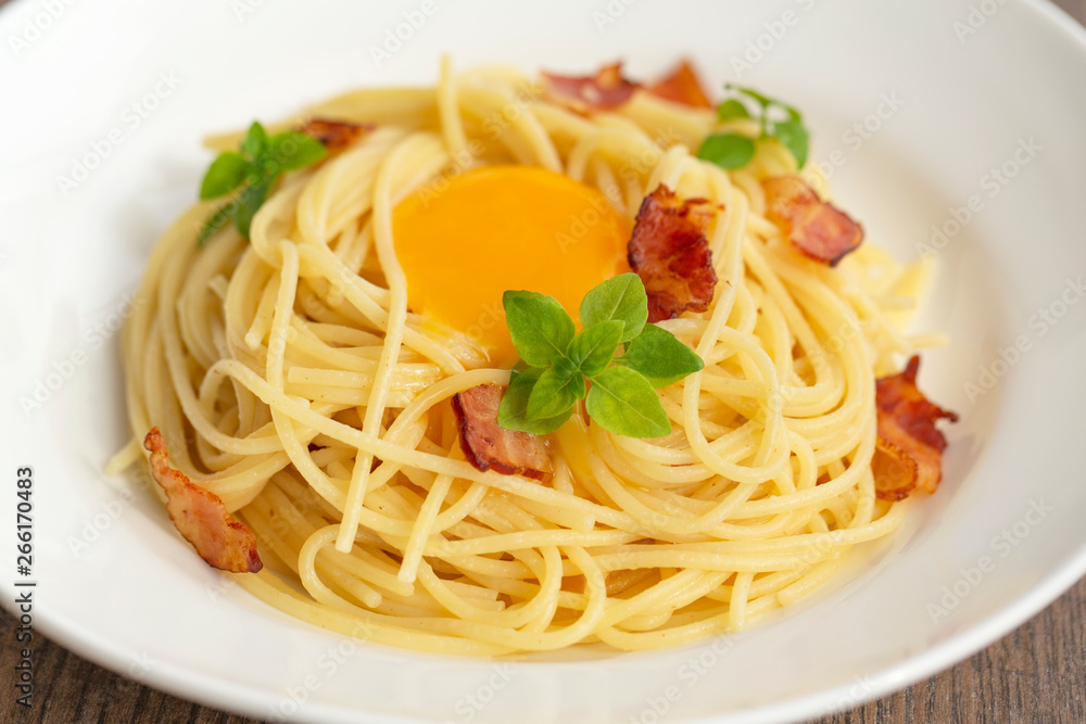 Carbonara pasta, spaghetti with pancetta, egg, hard parmesan cheese, basil and cream sauce. Traditional italian cuisine. Carbonara pasta, spaghetti with pancetta, egg, hard parmesan cheese, basil and cream sauce. Traditional italian cuisine.