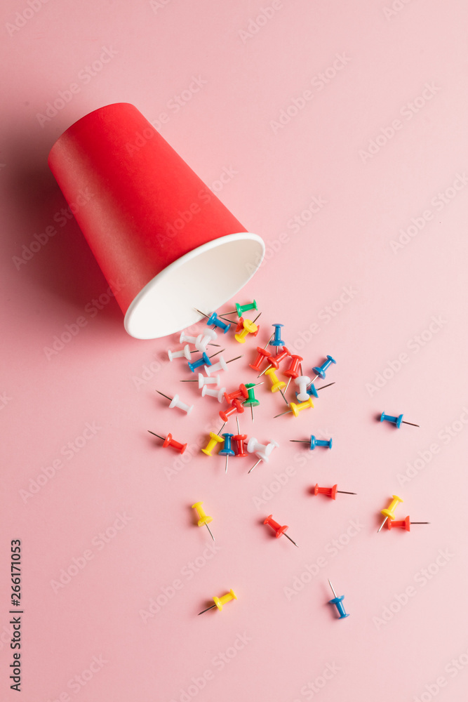 many pins scattered on the pink table. hobby, useful item for paperwork. top view photo. close up top view photo. minimal style many pins scattered on the pink table. hobby, useful item for paperwork. top view photo. close up top view photo. minimal style