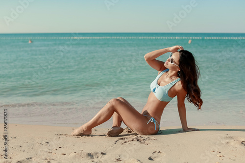 A Beautiful Woman With Sexy Fit Body In Fashion Bikini Relaxing At sea Edge. Female With Long Legs