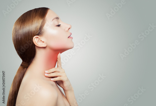 Young Woman with a Sore Throat. Woman Puts Hands on the Neck photo