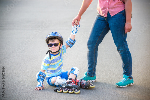 Preschooler falls over while rollerblading with mother in the park