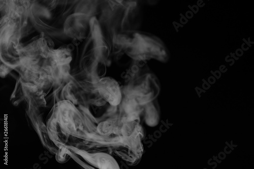 White smoke on a black background. Texture of smoke. Clubs of white smoke on a dark background for an overlay © alexkich