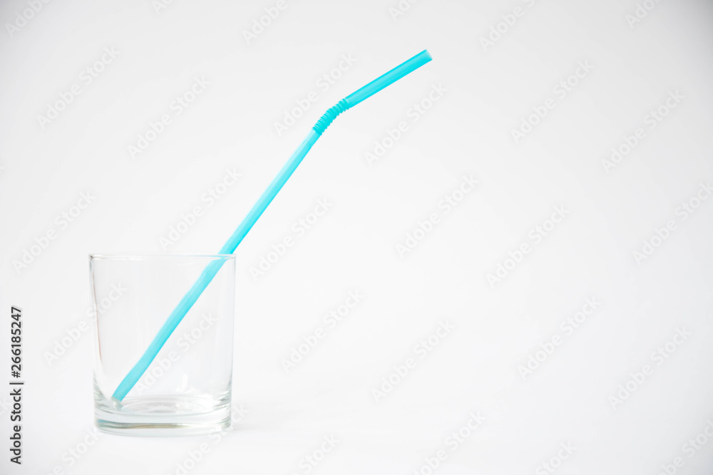 The glass with plastic tube on white background. Art soft focus The glass with plastic tube on white background. Art soft focus