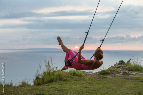 woman swinging on a swing on a tropical island