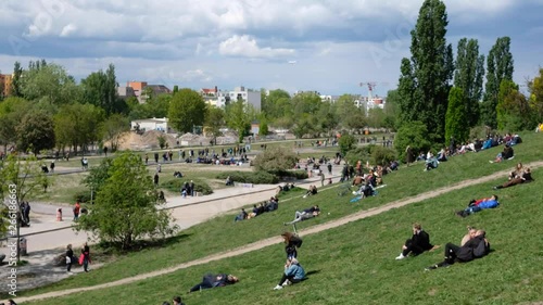 People on meadow  in crowded public park (Mauerpark) on a sunny day in Berlin, Prenzlauer Berg