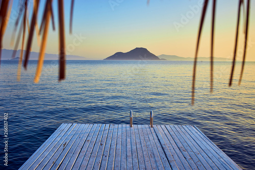 Fototapeta Naklejka Na Ścianę i Meble -  Bungalow on the sea at sunset. Wooden pavilions on the shore of a sandy beach - Bodrum, Turkey