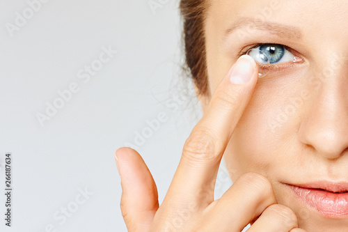 Young woman puts contact lens in her eye. Eyewear, eyesight and vision, eye care and health, ophthalmology and optometry concept photo