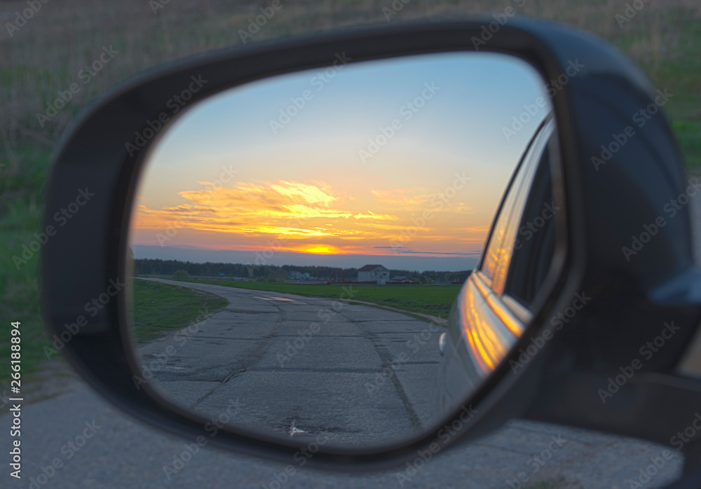 Reflection of the sunset in the car mirror. Bright reflection of the sunset in the car mirror